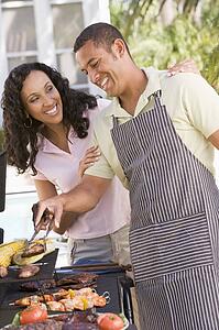 Couple Cooking On A Barbeque