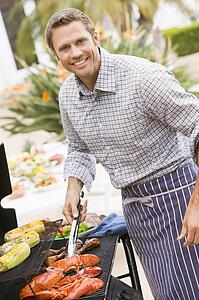 Man Barbequing In A Garden