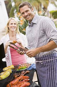 Couple Cooking On A Barbeque