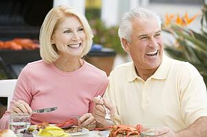 Couple Enjoying A Barbequed Meal In The Garden