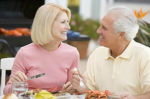 Couple Enjoying A Barbequed Meal In The Garden