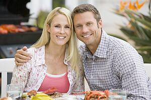Couple Enjoying A Barbequed Meal In The Garden