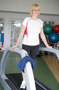 Woman Running On Treadmill At Gym