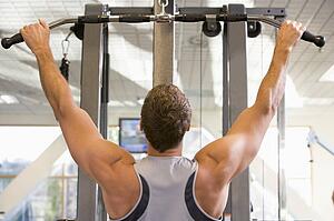 Man Weight Training At Gym