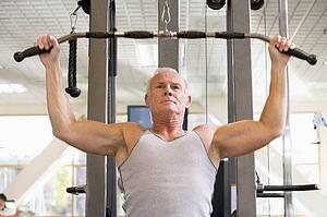 Man Weight Training At Gym