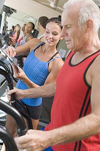 Personal Trainer Instructing Man On Treadmill