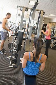 Group Of People Weight Training At Gym