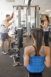 Group Of People Weight Training At Gym