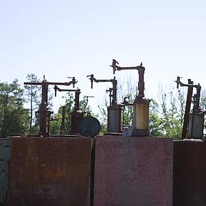 Old rusted metal machinery silhouetted against sky