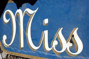 Blue sign with the word 'Miss' in cursive written on it.