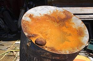 Old weathered oil barrel with rusty top.