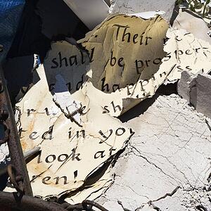 Pages of old weathered bible verse lying in junkyard.