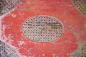 Old red patterned piece of metal.