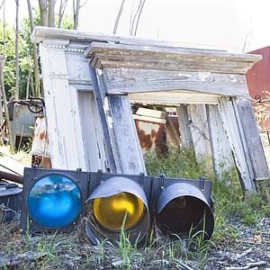 Old traffic light on ground in junkyard.