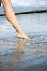 Woman dipping her toe in the water to test temperature