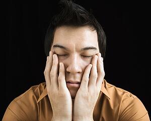 Man with hands on face