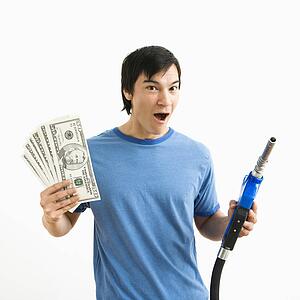 Man with happy expression holding money and gas pump nozzle