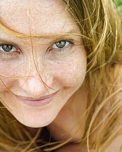 Close up portrait of attractive redheaded woman looking at viewer