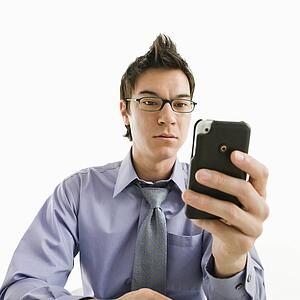Businessman with serious expression looking at his pda cellphone