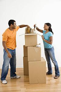Male and female couple packing cardboard boxes with shoes