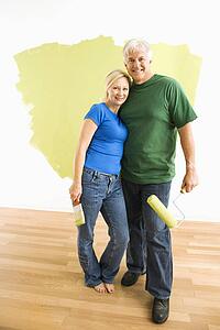 Couple in front of wall they are painting green