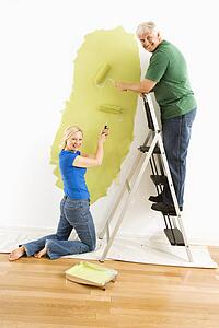 Couple painting wall green
