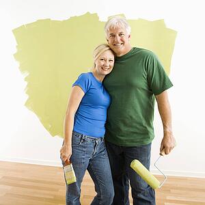 Couple in front of wall they are painting green