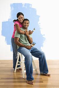Couple next to half-painted wall