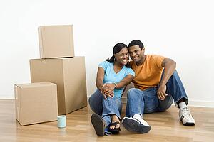 Couple sitting on floor next to moving boxes