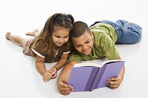 Brother and sister reading book together