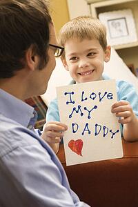 Boy giving father a drawing