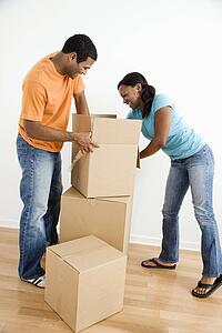 Male and female couple packing cardboard boxes