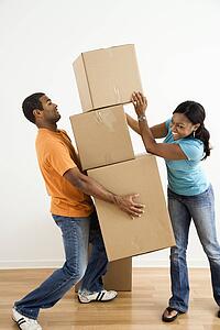 Female placing boxes on large stack man is holding