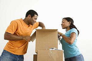 Male and female couple packing cardboard boxes