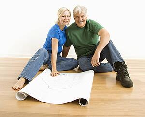 Couple sitting on floor with architectural blueprints