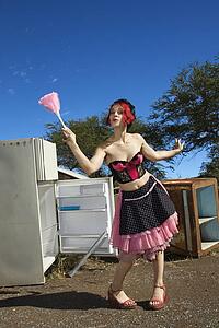 Young adult Caucasian female house cleaning in junkyard.