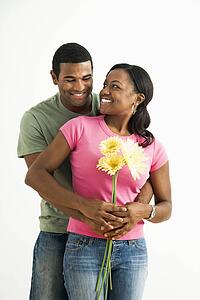 Portrait of smiling couple standing looking at each other.