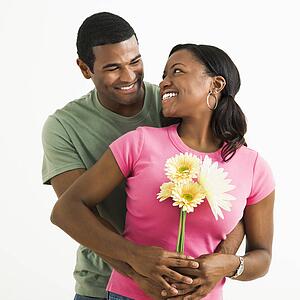 Portrait of smiling couple standing looking at each other.