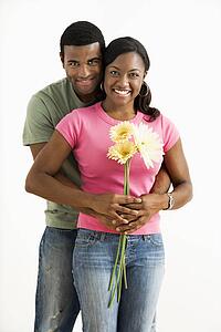 Portrait of smiling couple standing looking at viewer.