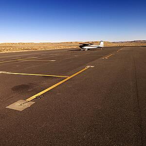 Plane in distance parked on tarmac at Canyonlands Field Airport, Utah, United States.