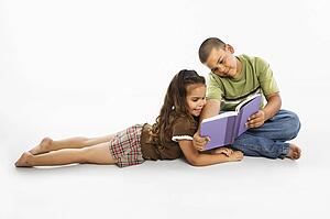 Brother and sister reading book together