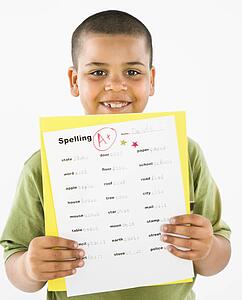 Boy proudly showing paper with A+