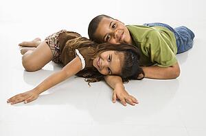 Brother and sister lying on floor 