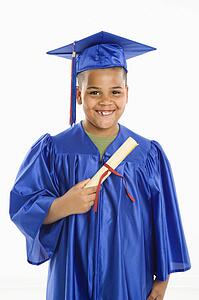 Boy wearing blue graduation gown holding diploma