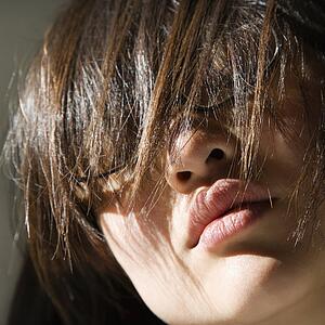 Close up of pretty young woman with hair covering eyes