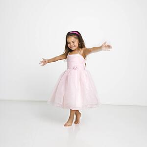 Cute little hispanic girl wearing pink dress dancing.