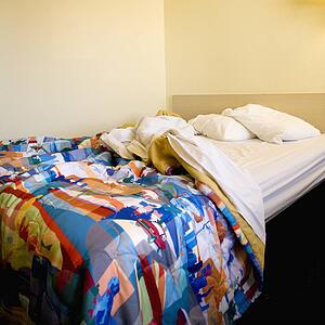 Interior shot of motel room with messy unmade bed