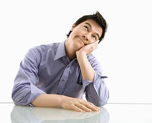 Young business man sitting and daydreaming.