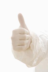 Hand wearing white rubber glove giving the thumbs up signal