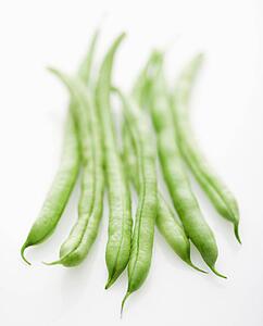 Selective focus shot of green beans on white background